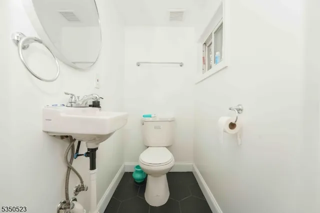 a bathroom with a sink toilet and a mirror