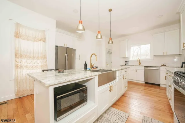 a kitchen with a stove a sink a center island and a window