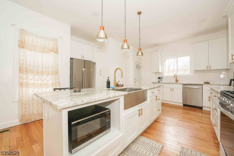 21 Woodland Road Bloomfield, NJ 07003 - Photo 19 of 20 a kitchen with a stove a sink a center island and a window