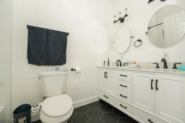 a bathroom with a toilet a sink and mirror