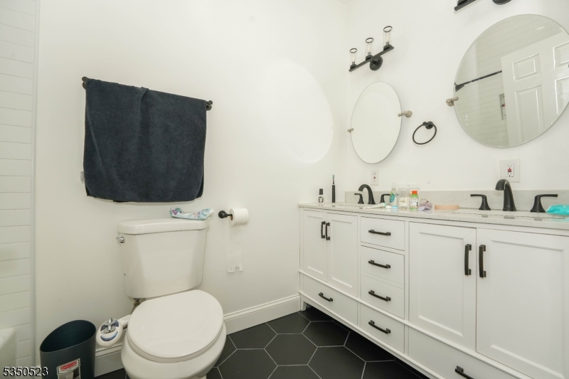 21 Woodland Road Bloomfield, NJ 07003 - Photo 10 of 20 a bathroom with a toilet a sink and mirror