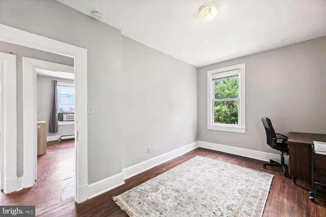 a view of a room with a window and wooden floor