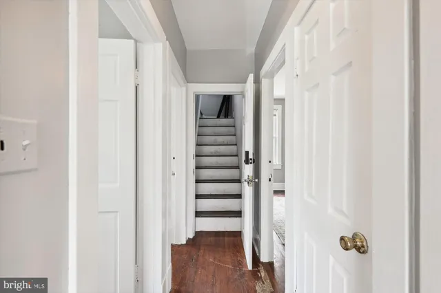 a view of a hallway with wooden floor and entryway