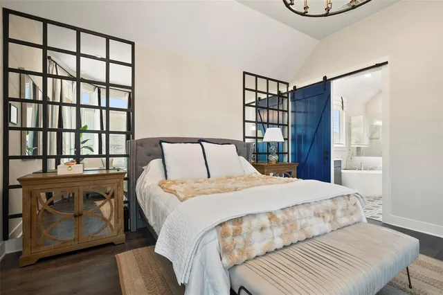 a bedroom with a bed couch and windows