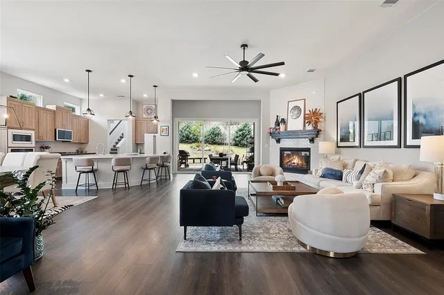 a living room with furniture a fireplace and a large window