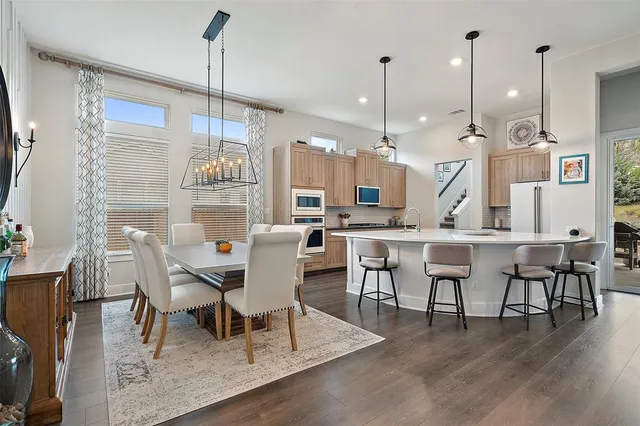a dining room with stainless steel appliances kitchen island a table and chairs