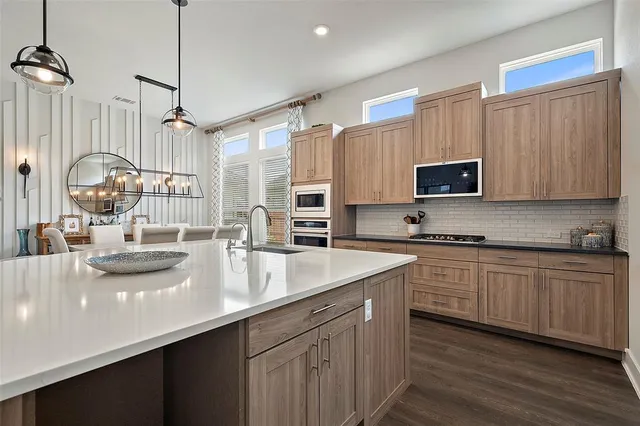 a kitchen with kitchen island granite countertop a sink appliances cabinets and a counter top space