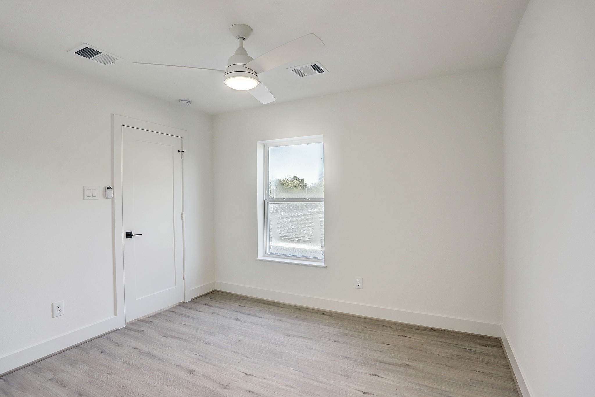 7407 Rusk Street, Unit B Houston, TX 77011 - Photo 14 of 24 an empty room with wooden floor and windows