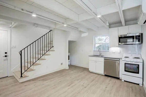 a kitchen with stainless steel appliances granite countertop a stove a sink and a microwave