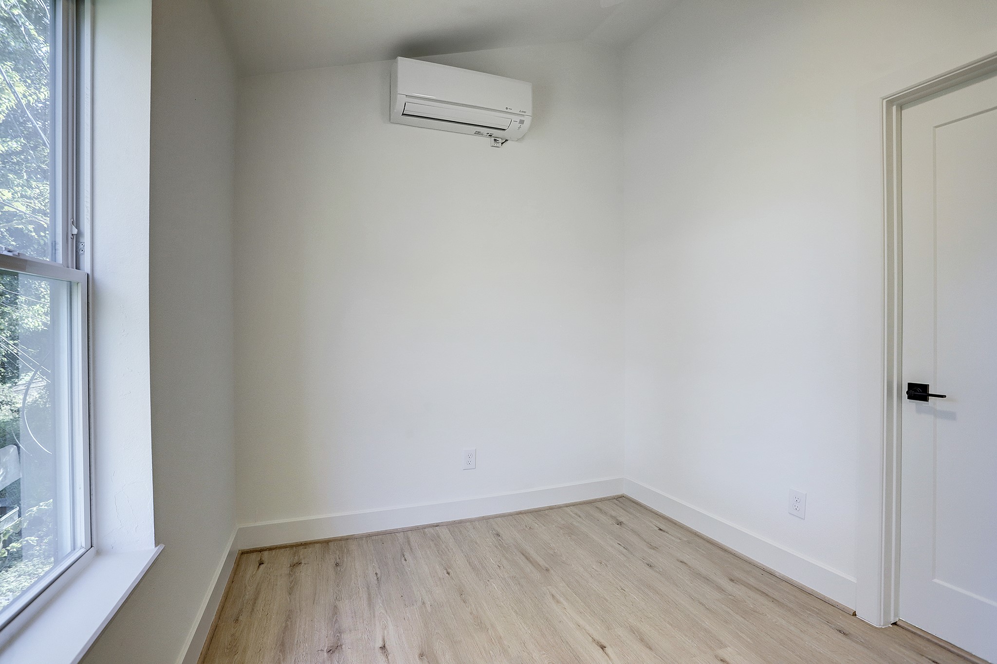 7407 Rusk Street, Unit B Houston, TX 77011 - Photo 6 of 24 a view of a small space with wooden floor and a window
