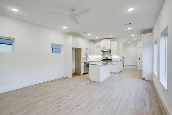 a view of kitchen with stainless steel appliances kitchen island granite countertop a refrigerator and a stove top oven
