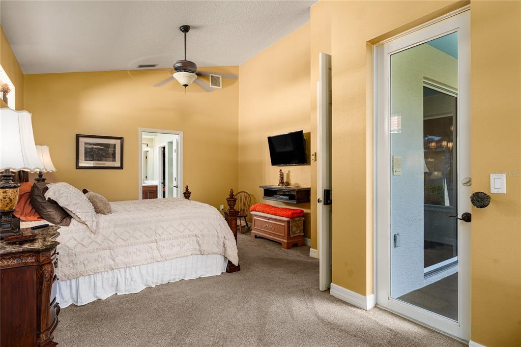6552 Tailfeather Way Bradenton, FL 34203 - Photo 21 of 65 a bedroom with a bed and a chandelier