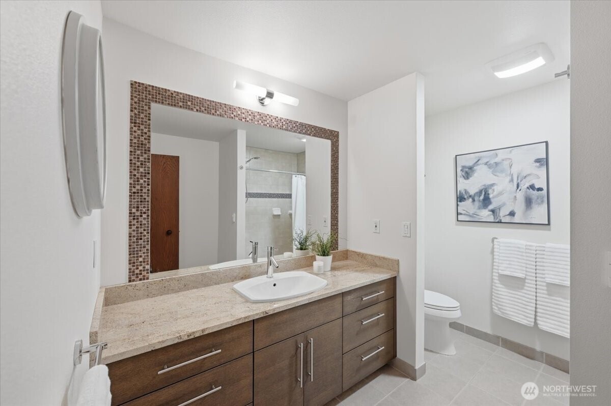 9418 Odin Way Bothell, WA 98011 - Photo 33 of 39 a bathroom with a granite countertop sink a toilet and a mirror
