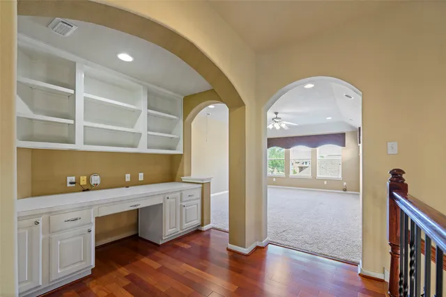 a hallway with a cabinet and wooden floor