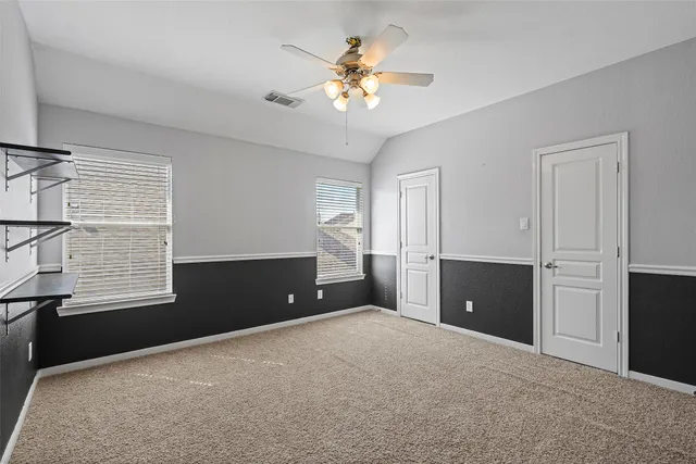 a view of an empty room with a window and a kitchen