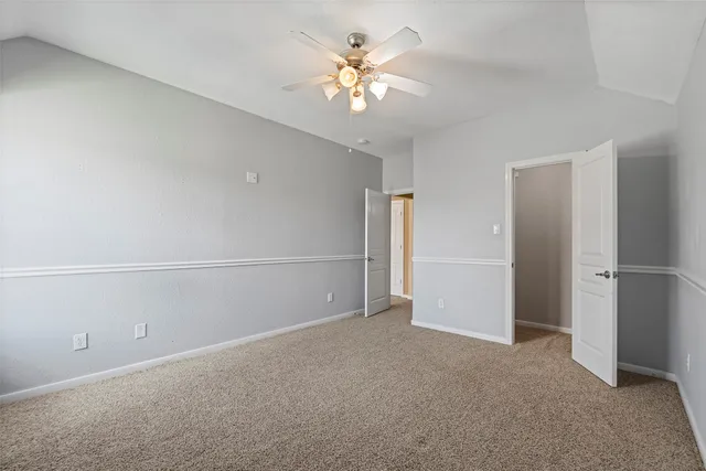 a view of an empty room with a ceiling fan