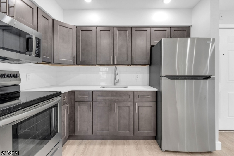 557 South Broad Street, Unit B1 Elizabeth, NJ 07202 - Photo 6 of 9 a kitchen with stainless steel appliances a refrigerator and a stove top oven