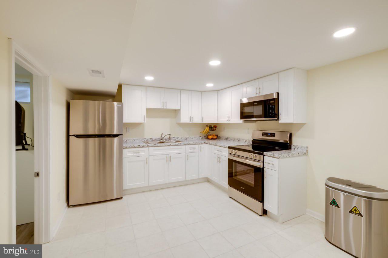 3312 Clay Street Silver Spring, MD 20902 - Photo 14 of 19 a kitchen with white cabinets stainless steel appliances and a refrigerator