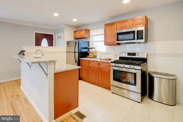 a kitchen with stainless steel appliances a stove microwave and sink