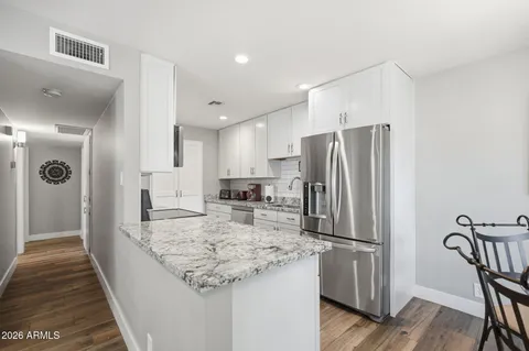 a kitchen with refrigerator and chairs