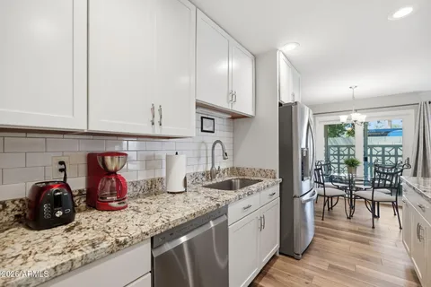 a kitchen with granite countertop a sink stainless steel appliances and cabinets