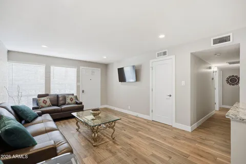 a living room with furniture and a wooden floor