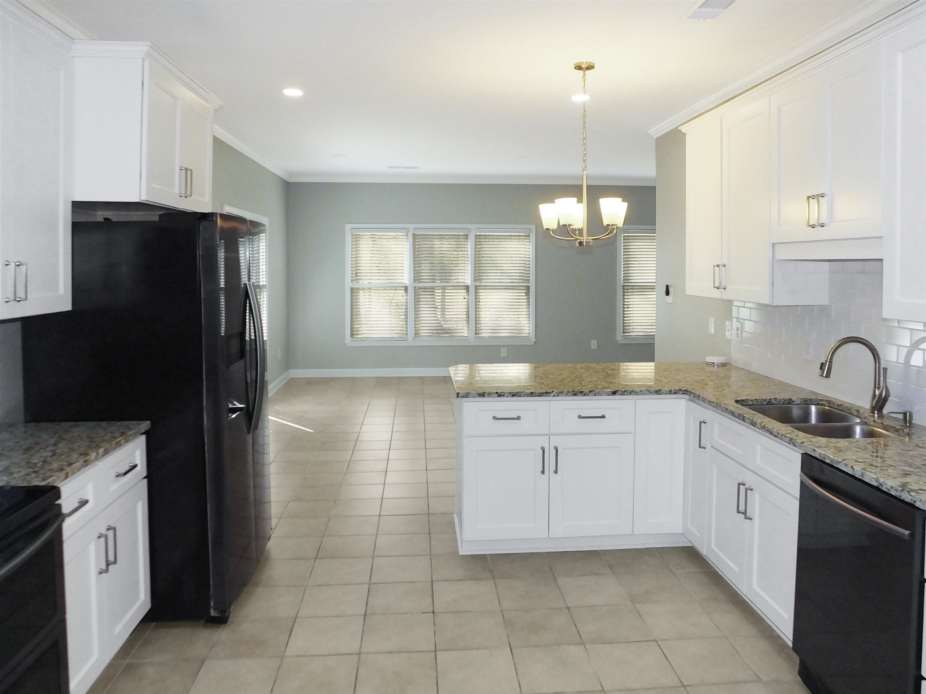 4323 Country Bridge Road Lakeland, TN 38002 - Photo 12 of 35 Kitchen featuring black appliances, a sink, tasteful backsplash, a peninsula, and an inviting chandelier