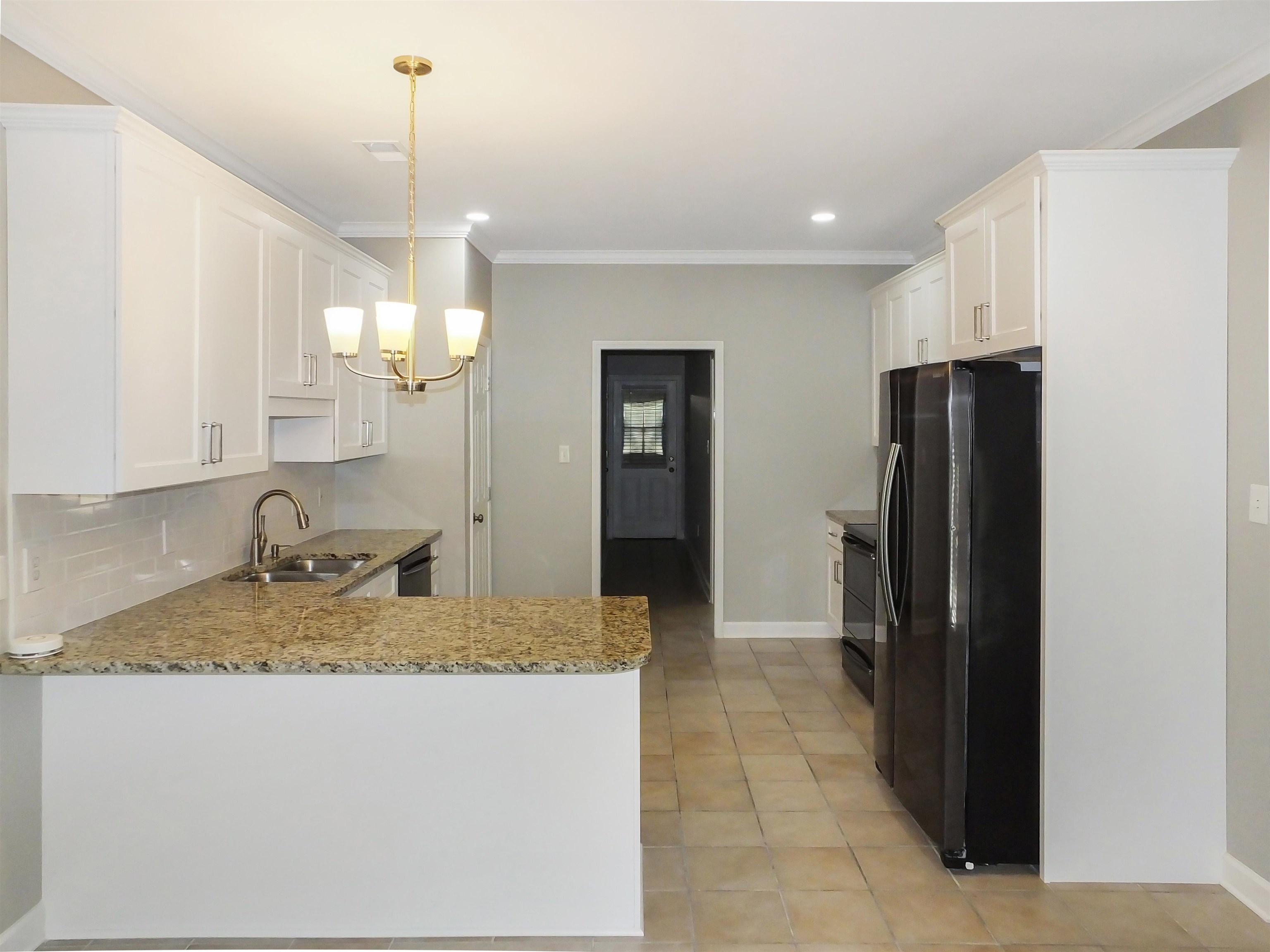 4323 Country Bridge Road Lakeland, TN 38002 - Photo 14 of 35 Kitchen with ornamental molding, decorative backsplash, an inviting chandelier, black appliances, and a sink