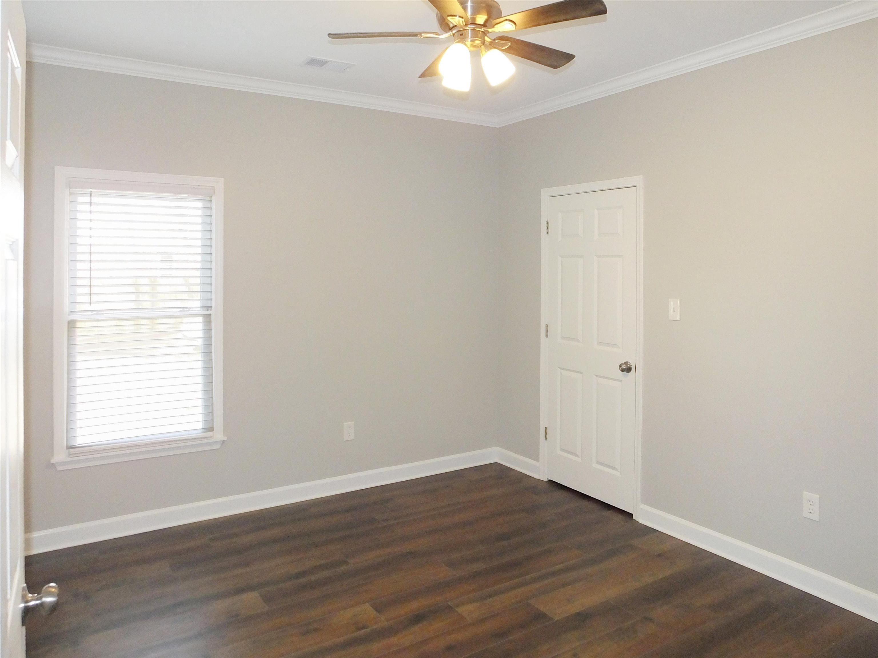 4323 Country Bridge Road Lakeland, TN 38002 - Photo 30 of 35 Spare room featuring visible vents, baseboards, ceiling fan, and dark wood-style flooring