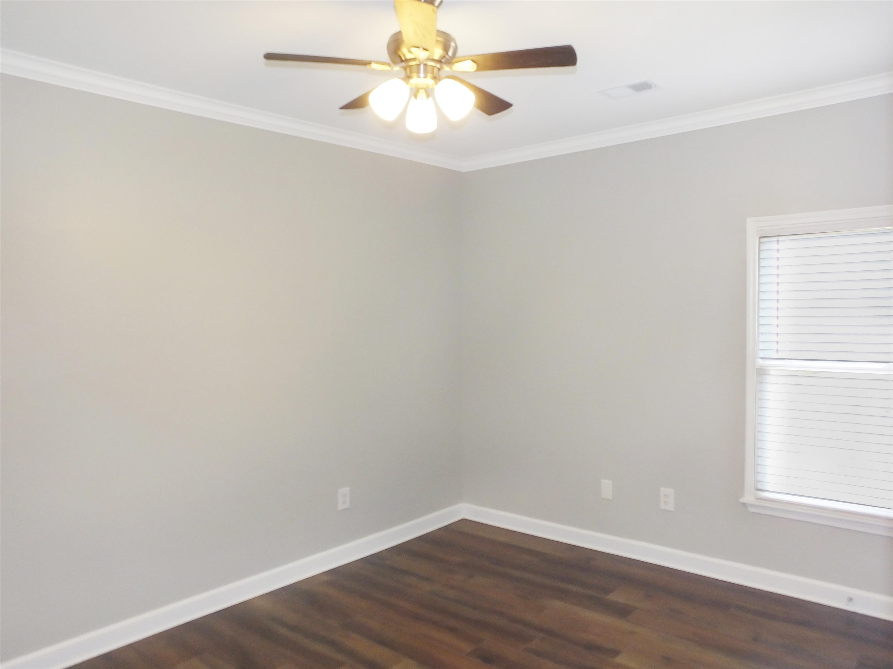 4323 Country Bridge Road Lakeland, TN 38002 - Photo 31 of 35 Empty room featuring ornamental molding, a ceiling fan, baseboards, and dark wood-style flooring