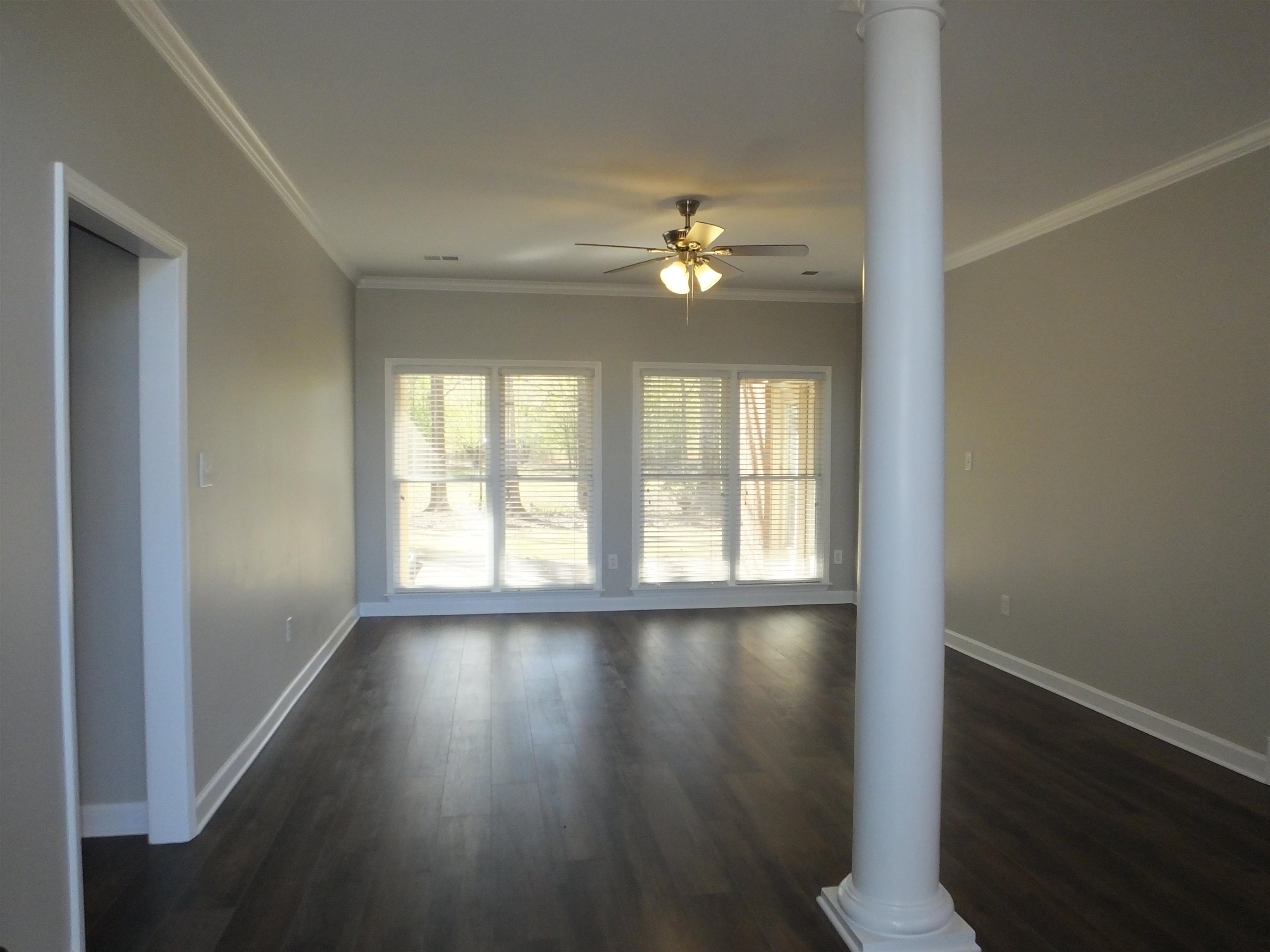 4323 Country Bridge Road Lakeland, TN 38002 - Photo 9 of 35 Unfurnished living room with ornamental molding, decorative columns, dark wood-type flooring, and ceiling fan