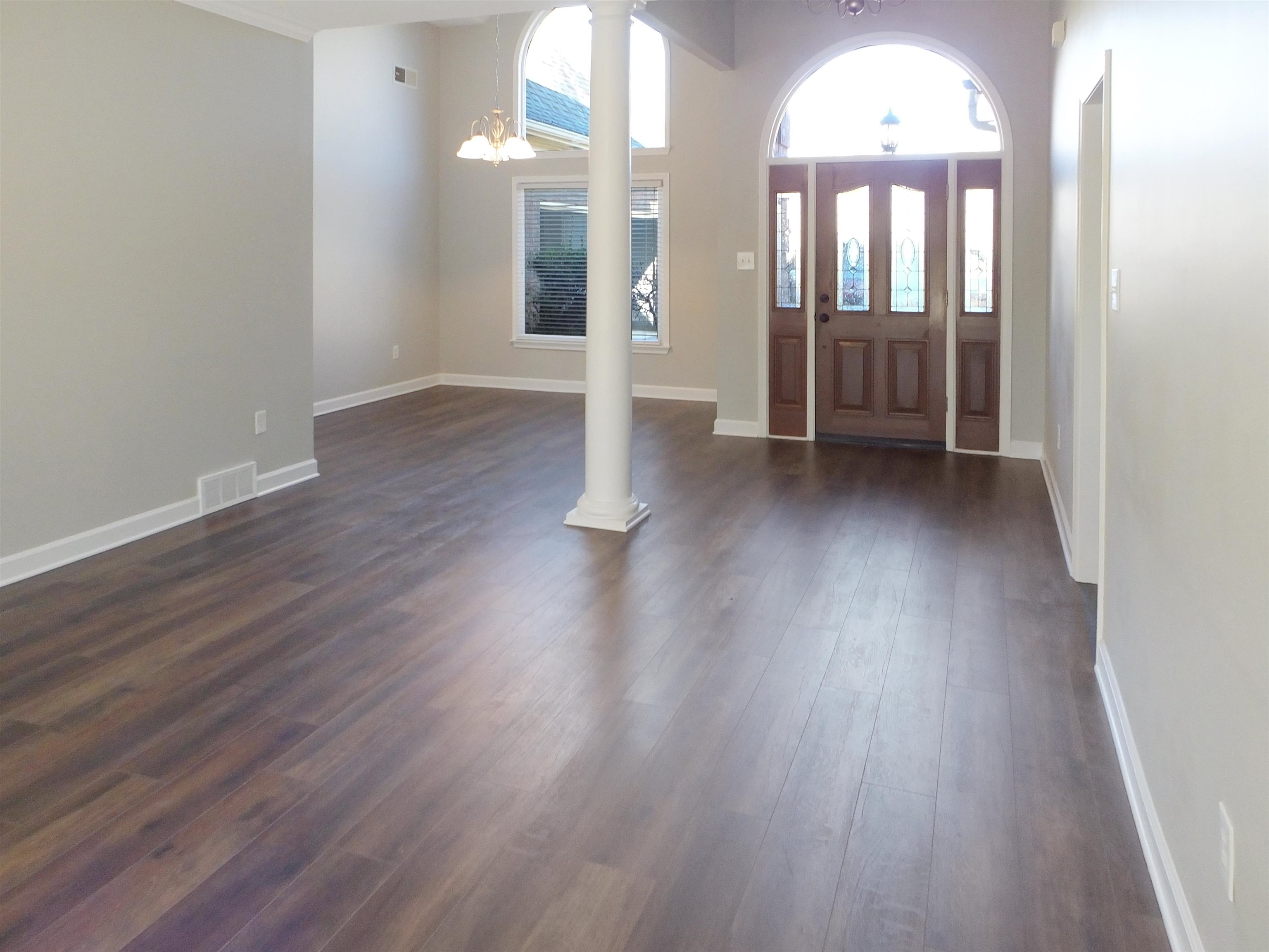 4323 Country Bridge Road Lakeland, TN 38002 - Photo 10 of 35 Entrance foyer with dark wood-style floors, visible vents, baseboards, an inviting chandelier, and decorative columns