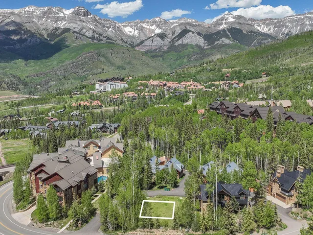 an aerial view of residential houses with outdoor space and trees