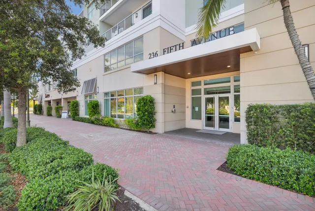 a view of a building with a yard and plants