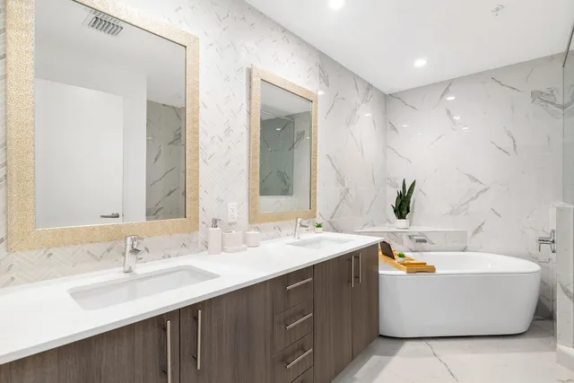 a bathroom with a tub double sink and mirror