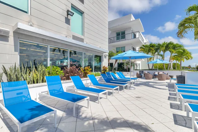 a view of a patio with a dining table and chairs under an umbrella