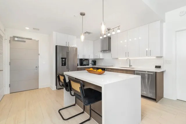 a kitchen with stainless steel appliances a table chairs and refrigerator