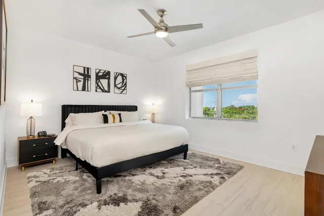 a bedroom with a bed and a painting on the wall