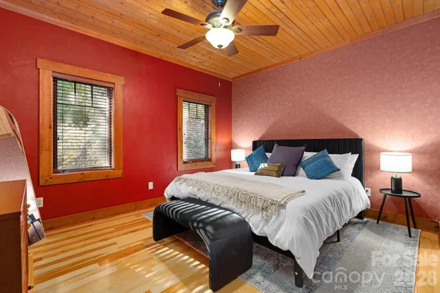 a bedroom with a bed a chandelier and a flat tv screen