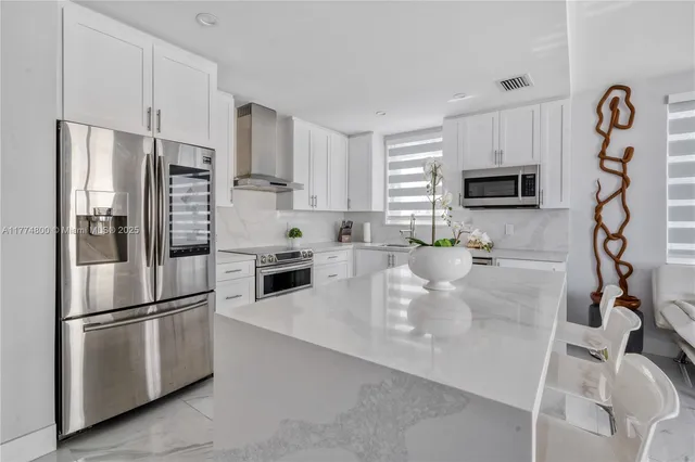 a kitchen with granite countertop a refrigerator a stove a microwave and cabinets