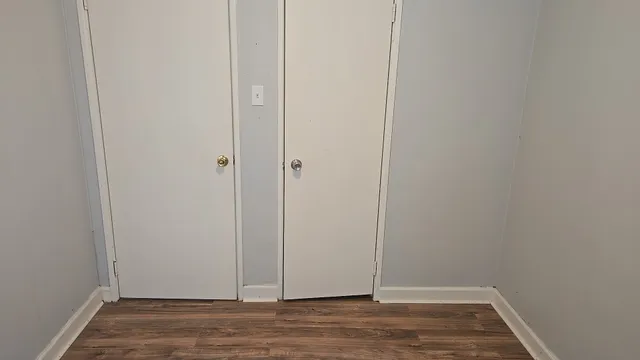 a view of a small space with wooden floor and a window