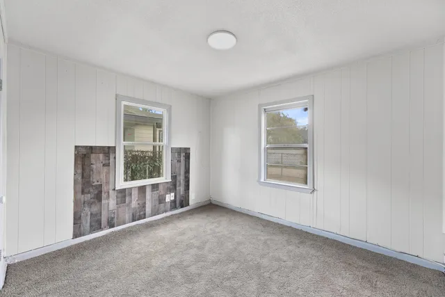 an empty room with windows and closet