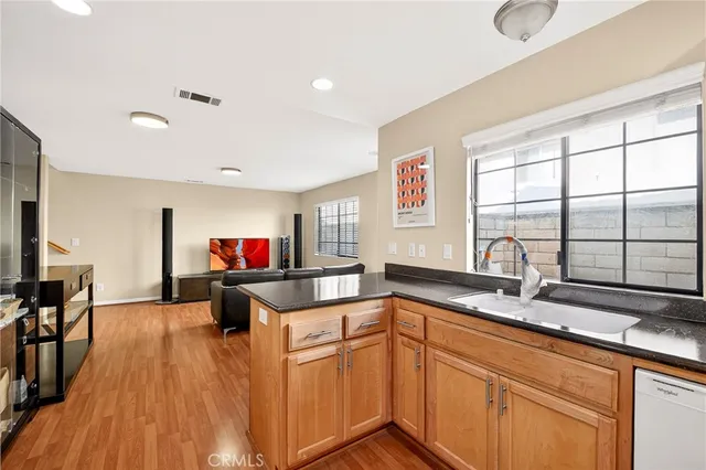 a kitchen with stainless steel appliances granite countertop a sink and wooden cabinets