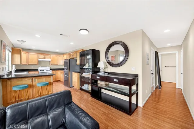 a living room with stainless steel appliances furniture a rug and a large window
