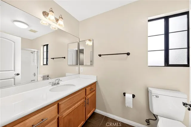 a bathroom with a double vanity sink mirror and toilet