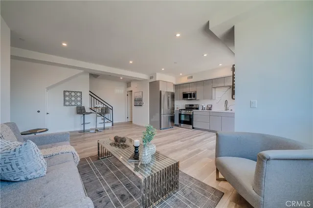a kitchen with stainless steel appliances kitchen island hardwood floor sink and stove