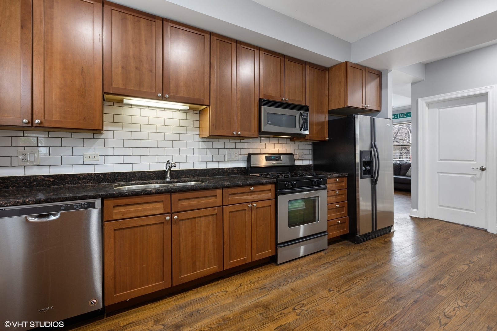 3522 North Racine Avenue, Unit 1N Chicago, IL 60657 - Photo 7 of 17 a kitchen with stainless steel appliances granite countertop wooden cabinets a refrigerator a sink and dishwasher a oven with wooden floor