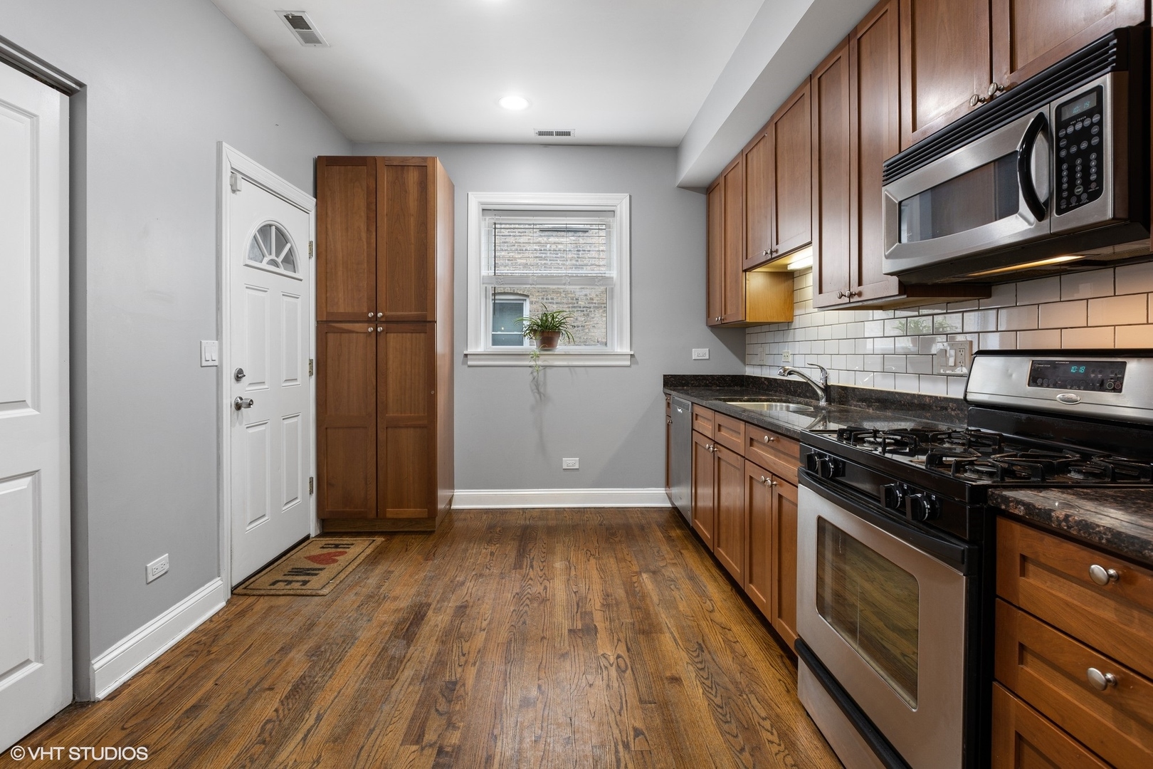 3522 North Racine Avenue, Unit 1N Chicago, IL 60657 - Photo 8 of 17 a kitchen with stainless steel appliances granite countertop a stove a refrigerator and a microwave