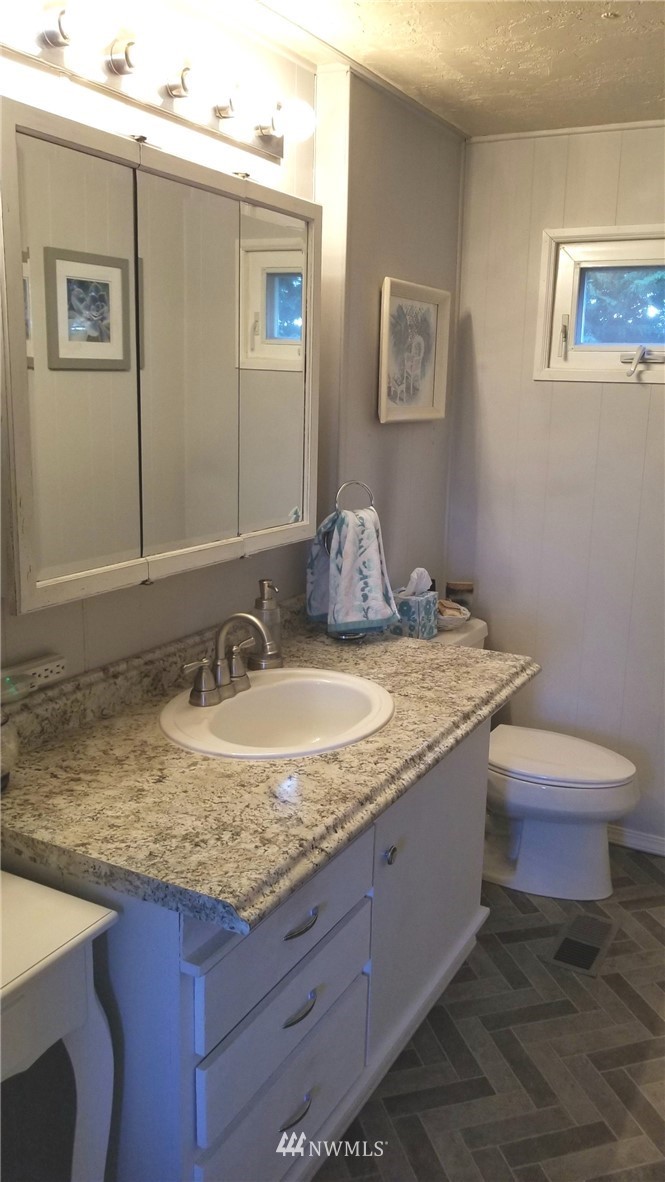 171 Spath Road Sequim, WA 98382 - Photo 15 of 21 a bathroom with a granite countertop sink and a mirror