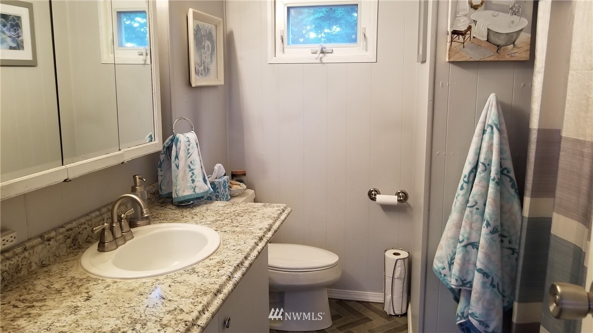 171 Spath Road Sequim, WA 98382 - Photo 16 of 21 a bathroom with a granite countertop sink toilet and a mirror